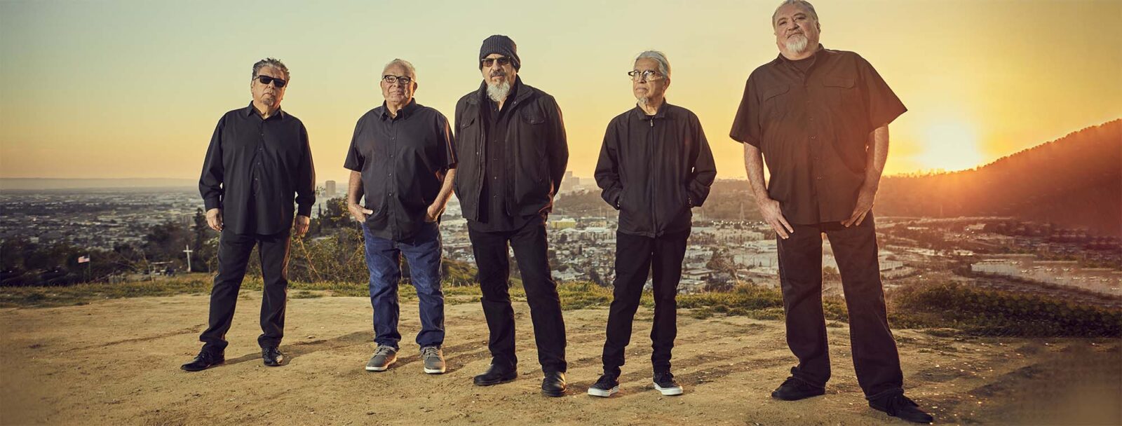 los lobos standing with a sunset view on their backs