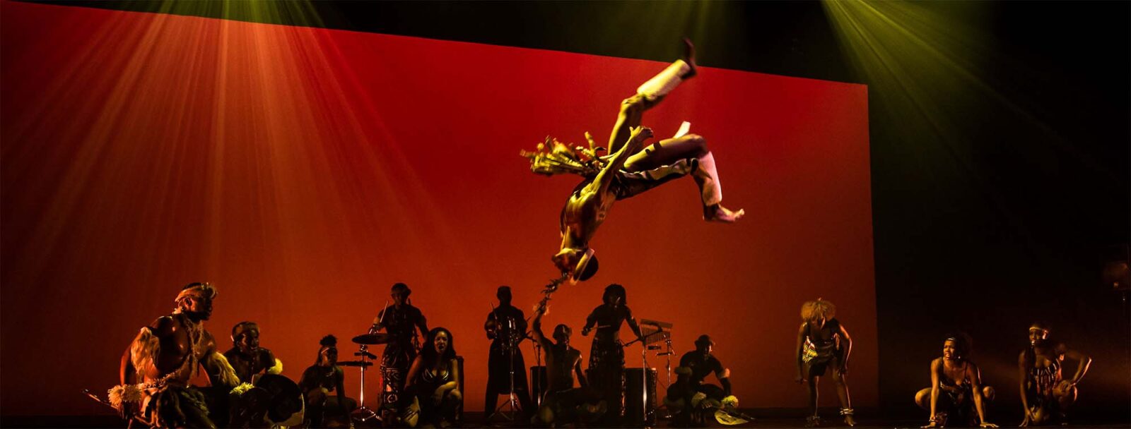 dancer flying through the air, red background