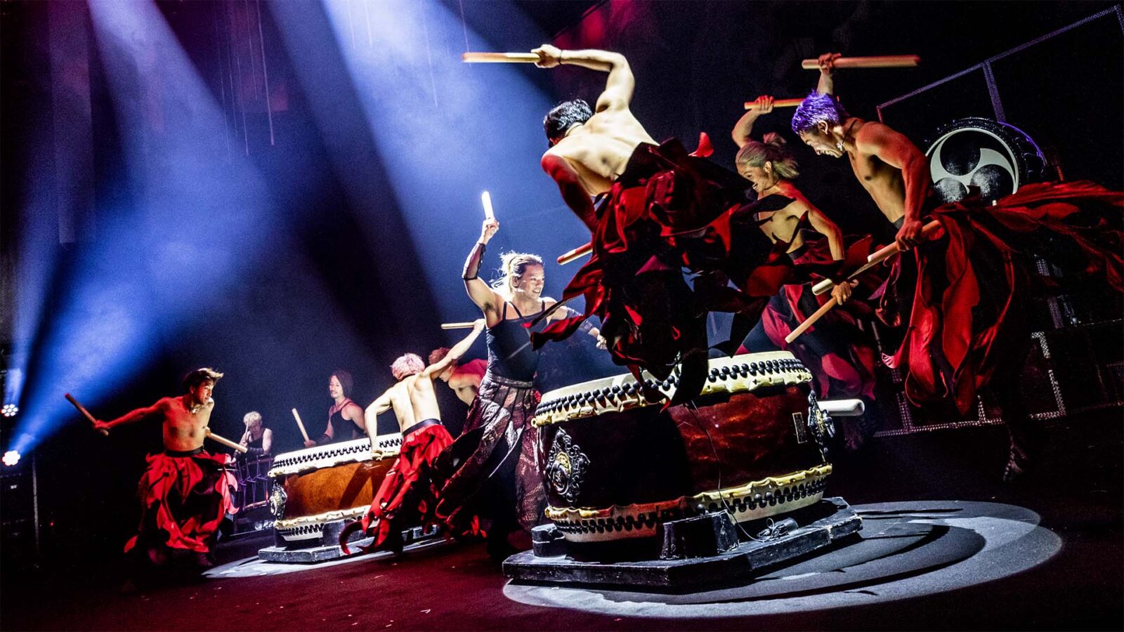 drums on stage and a group of Japanese players, drumming while jumping