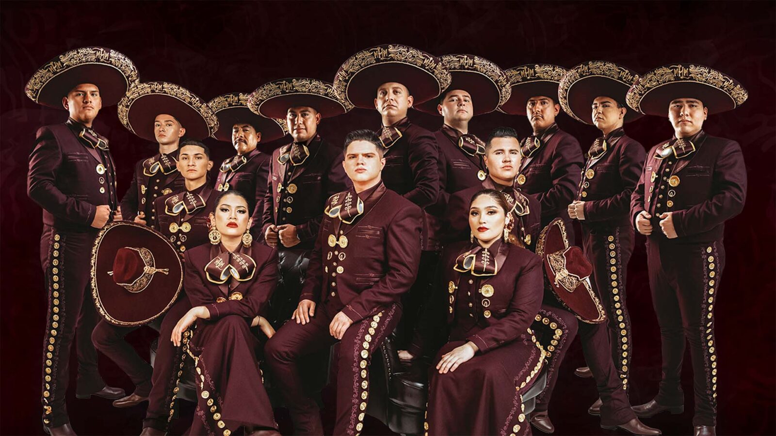 A group of mariachi artists wearing intricate maroon uniforms with their stylized hats.