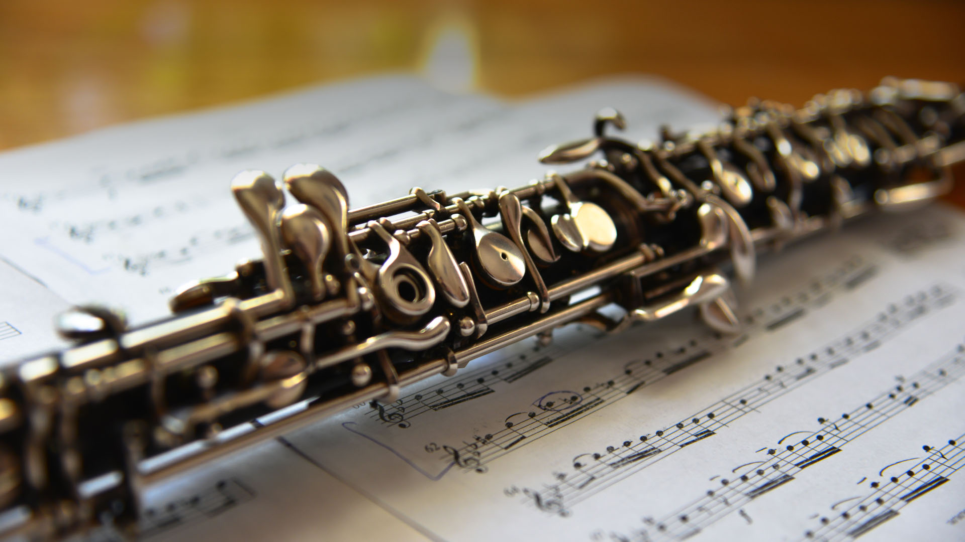 An oboe on top of music sheets on a wooden surface