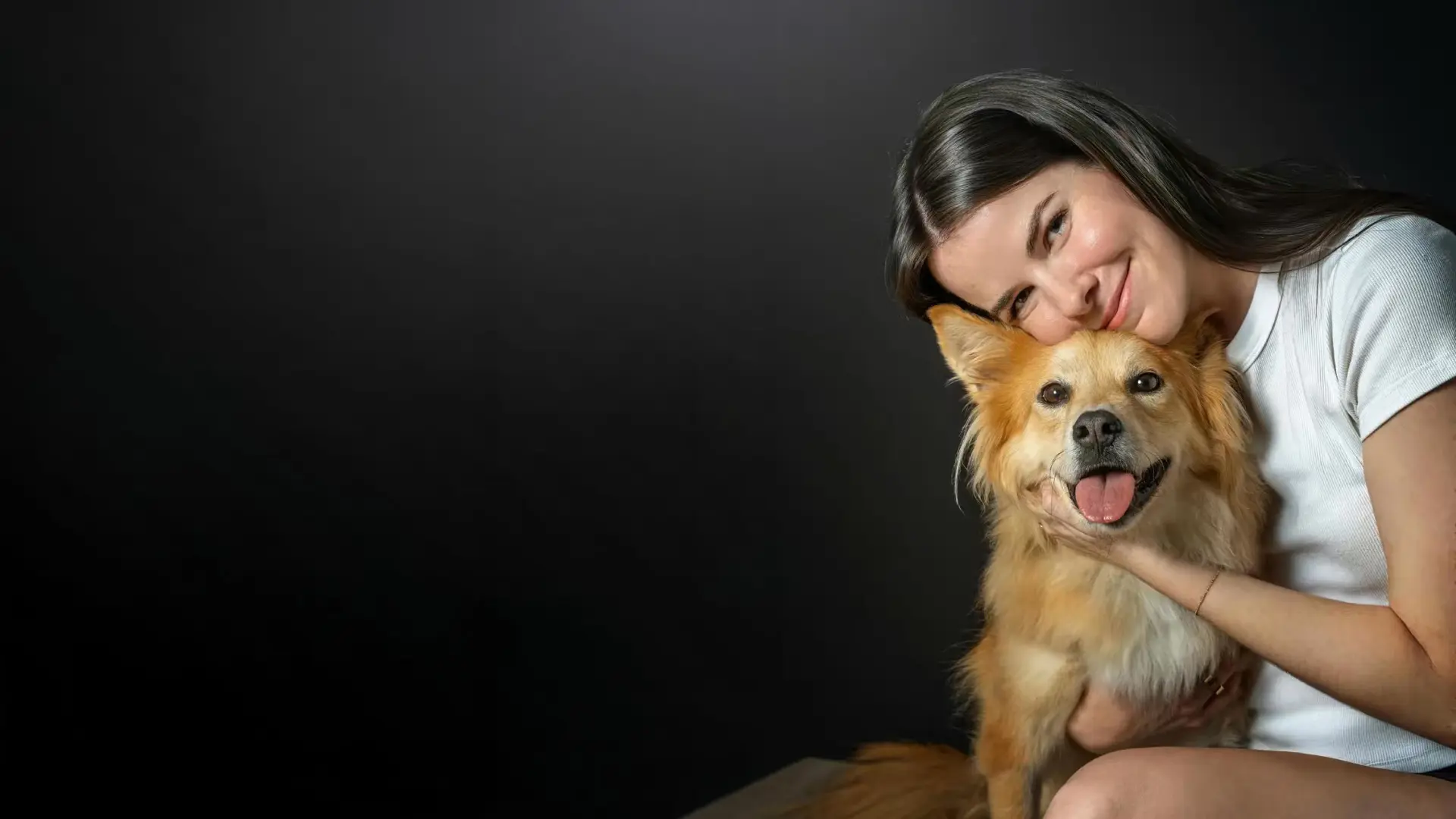Isabel Klee with a white T-shirt, hugging a cute yellow dog.